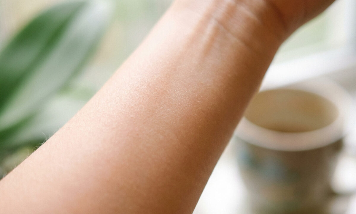 Gros plan sur l'avant-bras d'une personne, mettant en valeur la texture naturelle de la peau.