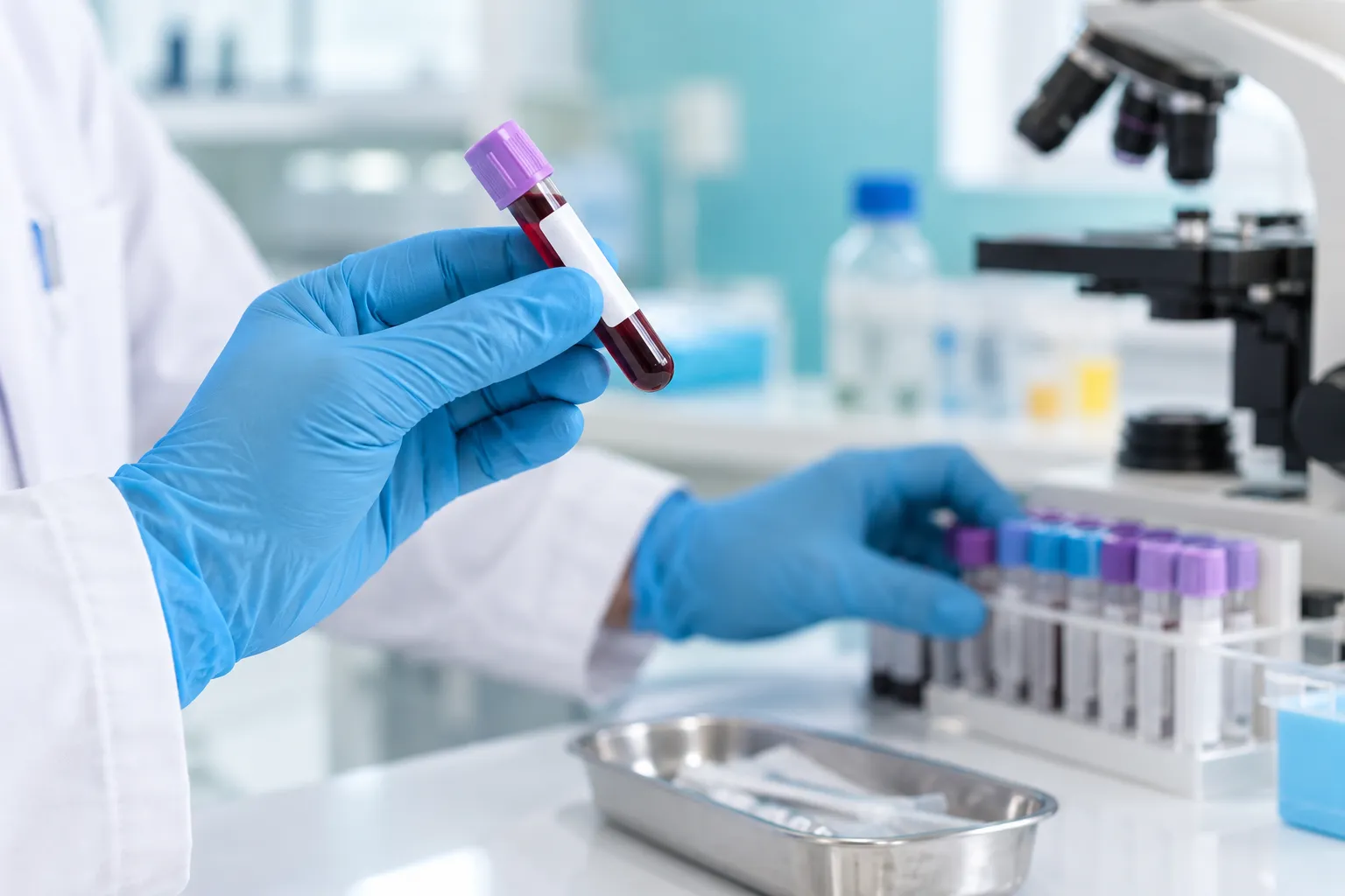 Tube de prélèvement sanguin tenu par une main gantée dans un laboratoire.